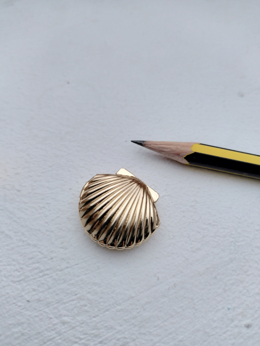 Muschel-Puderdose Miniatur-Puderdose in Form einer goldenen Muschel, abgebildet mit Bleistift für Größenvergleich