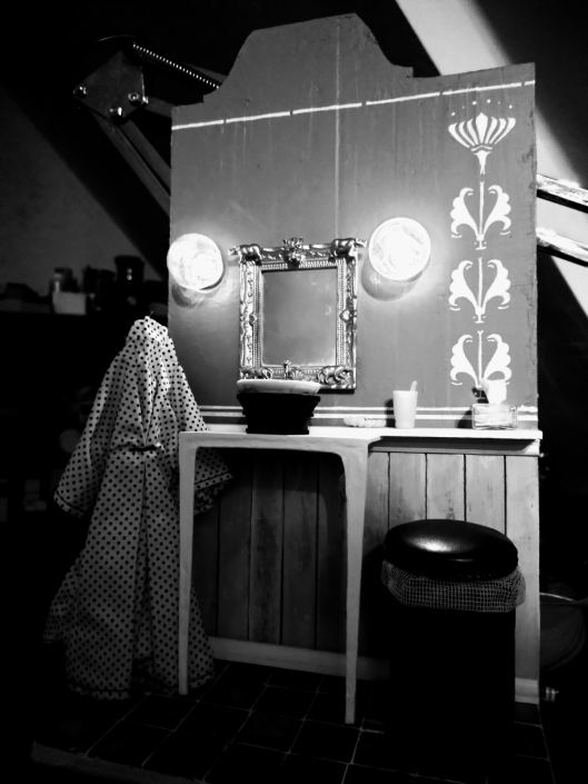 Sturmgrüner Waschraum in Schwarz-Weiß, aufgebaut wie eine dramatische Filmszene