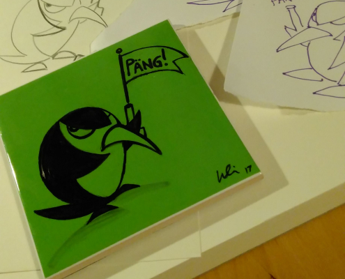 Grüne Fliese mit schwarzer Fineliner-Zeichung eines Pinguins, der eine abgefeuerte Startpistole hochhält