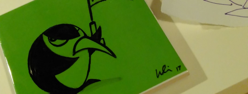 Grüne Fliese mit schwarzer Fineliner-Zeichung eines Pinguins, der eine abgefeuerte Startpistole hochhält