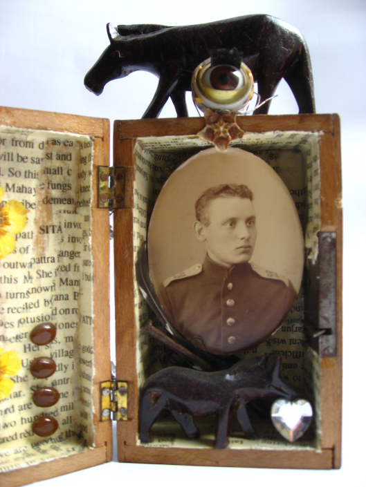 Mixed-Media-Objekt: Holzkästchen mit Foto, Pferdefigur, getrockneten Blüten, Bleilettern und anderen Fundstücken, geöffnet