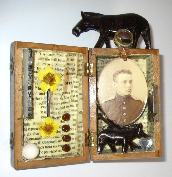 Mixed-Media-Objekt: Holzkästchen mit Foto, Pferdefigur, getrockneten Blüten, Bleilettern und anderen Fundstücken, geöffnet