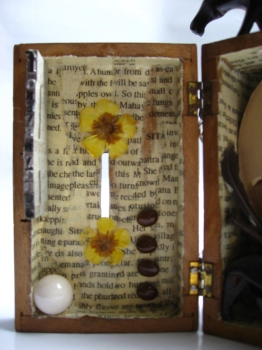 Mixed-Media-Objekt: Holzkästchen mit Foto, Pferdefigur, getrockneten Blüten, Bleilettern und anderen Fundstücken, geöffnet, Innenseite links