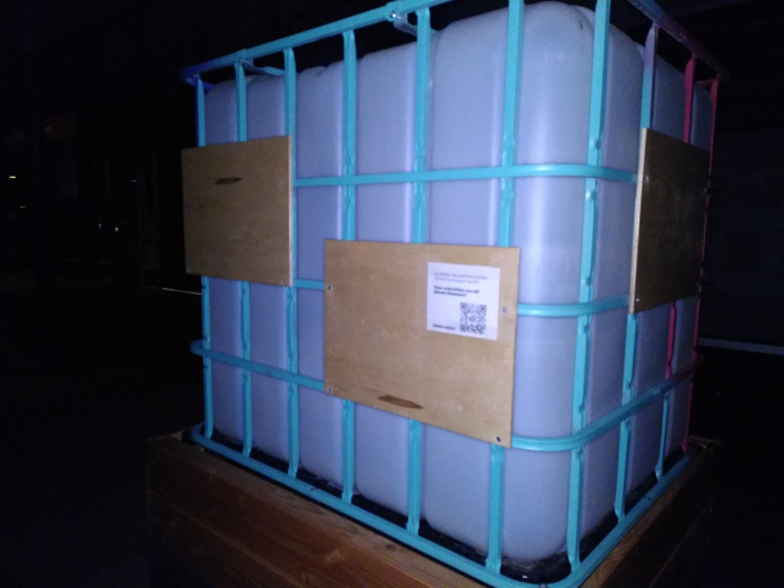 1.000-Liter_Wassertank mit türkisblauem Metallgestell und Holztafeln