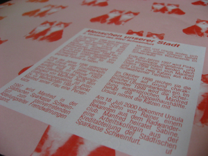 Zeitungsartikel "Menschen unserer Stadt" auf einer Tapete mit Katzenmuster